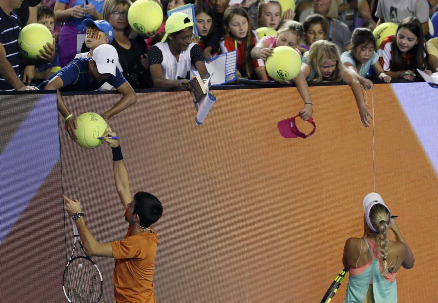 L’immancabile firma da parte di Djokovic e Wozniacki (Epa)